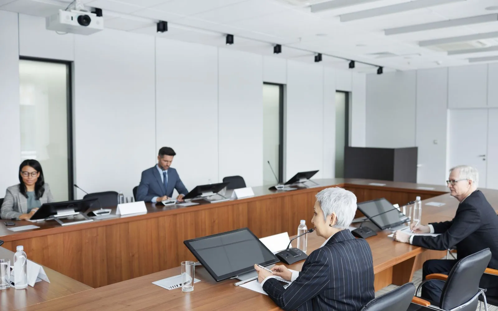 Des participants réunis autour de la table d'une salle de conseil