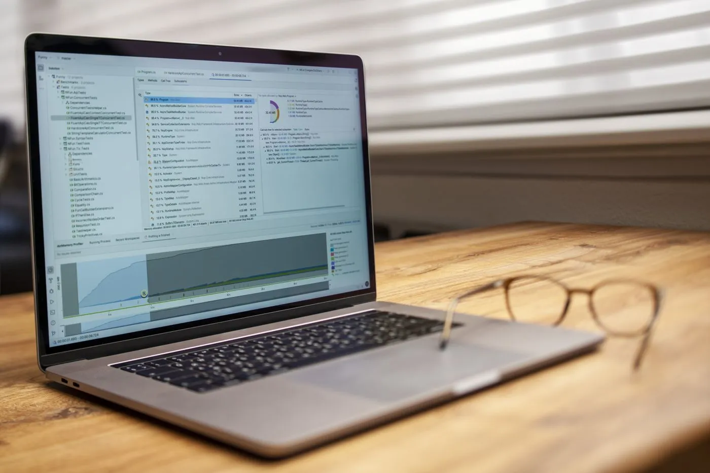 Un ordinateur portable ouvert sur un logiciel de gestion, sur un bureau en bois